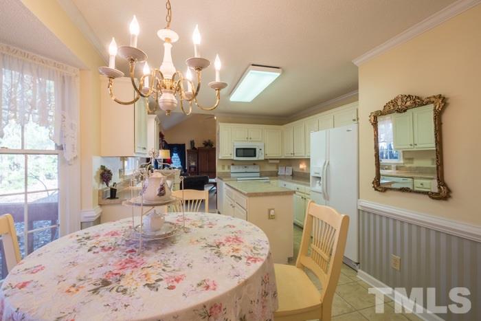5624 Barham Court Raleigh, NC 27613 - Photo 6 of 19 a dining room with wooden floor and chandelier