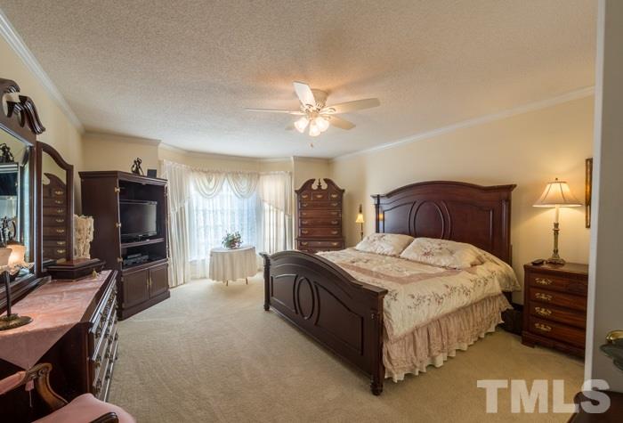 5624 Barham Court Raleigh, NC 27613 - Photo 7 of 19 a bedroom with a bed and a chandelier