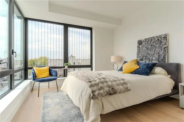 a bedroom with a bed and large windows