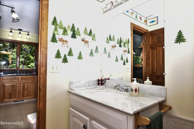 a bathroom with a granite countertop sink and a mirror