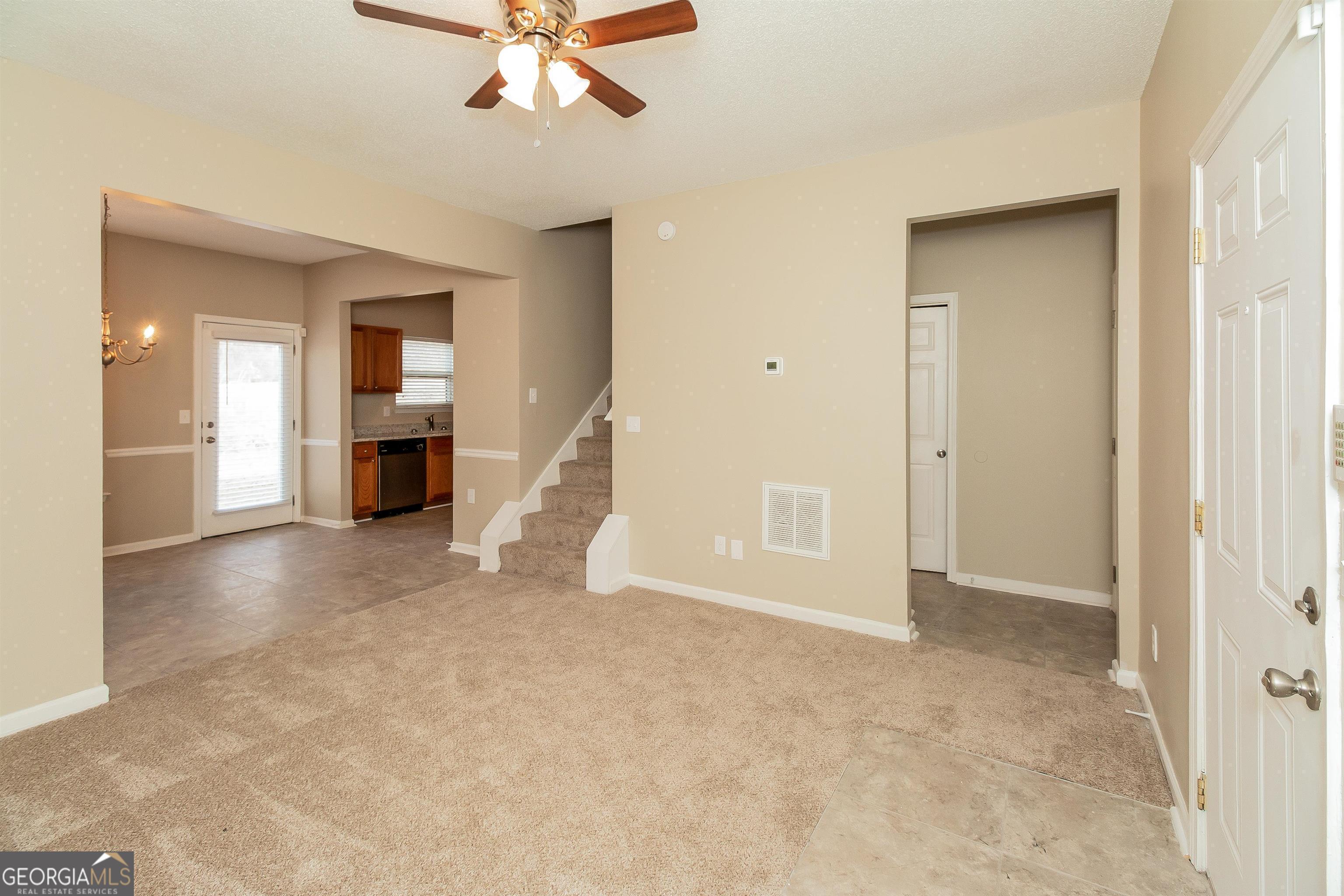 2413 Hackamore Drive Atlanta, GA 30349 - Photo 7 of 15 an empty room with chandelier fan and windows