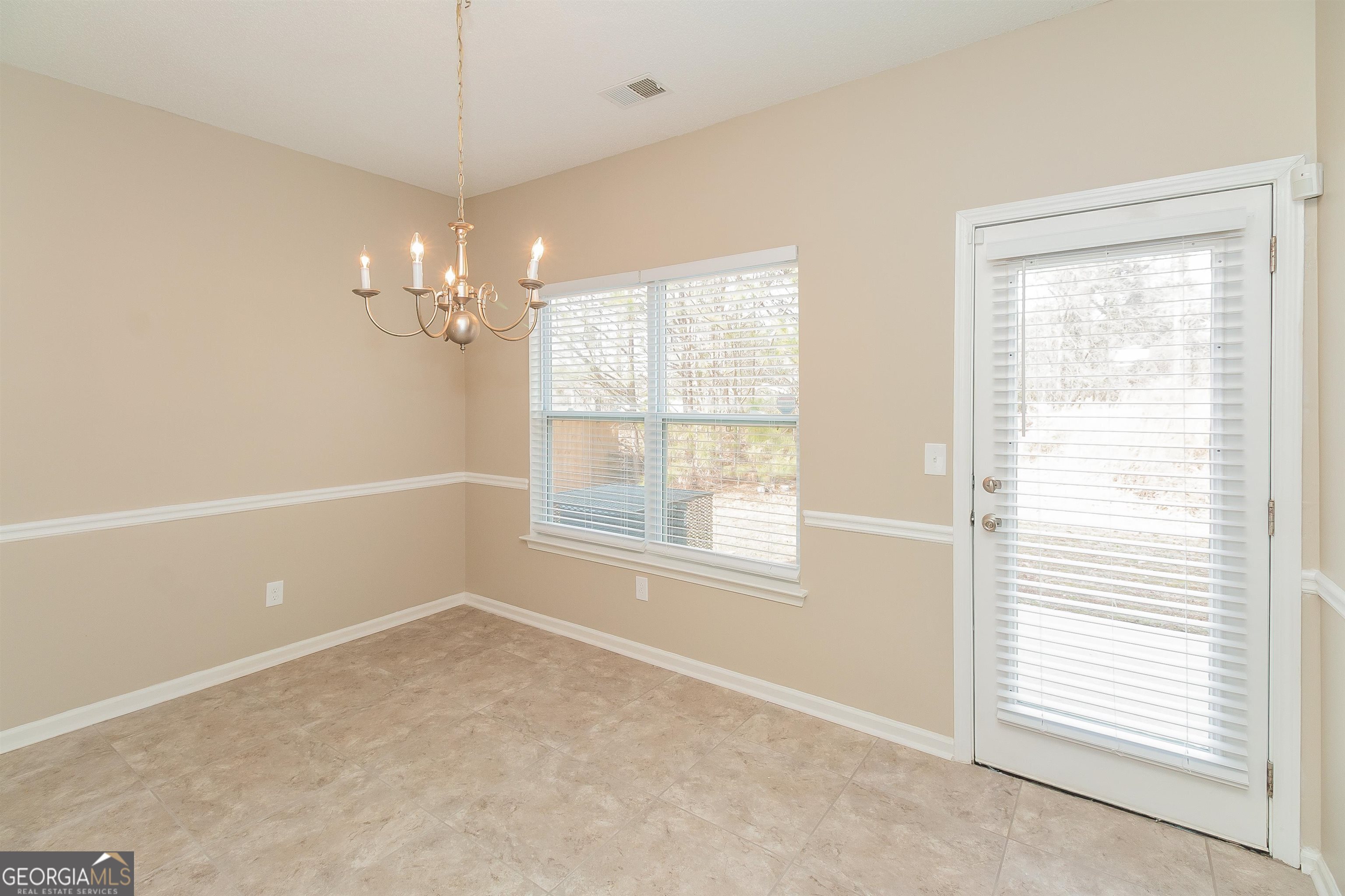 2413 Hackamore Drive Atlanta, GA 30349 - Photo 9 of 15 an empty room with chandelier fan and windows