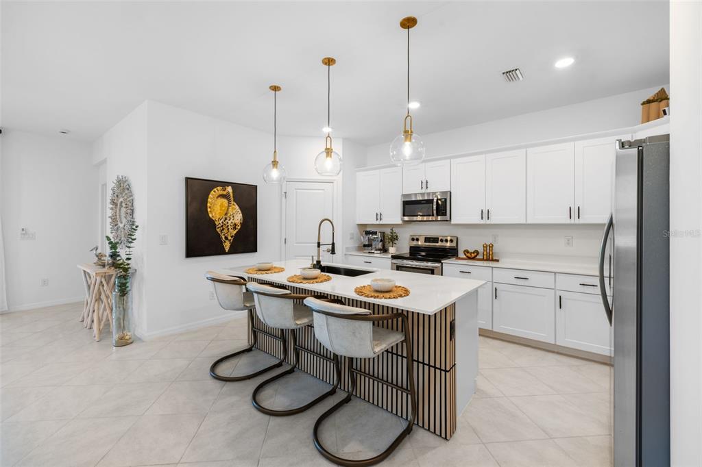 1842 West Isles Road Port Charlotte, FL 33953 - Photo 6 of 65 a kitchen with stainless steel appliances granite countertop a sink a stove a refrigerator cabinets and chairs
