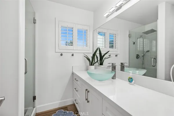 a bathroom with a sink a large mirror and a shower