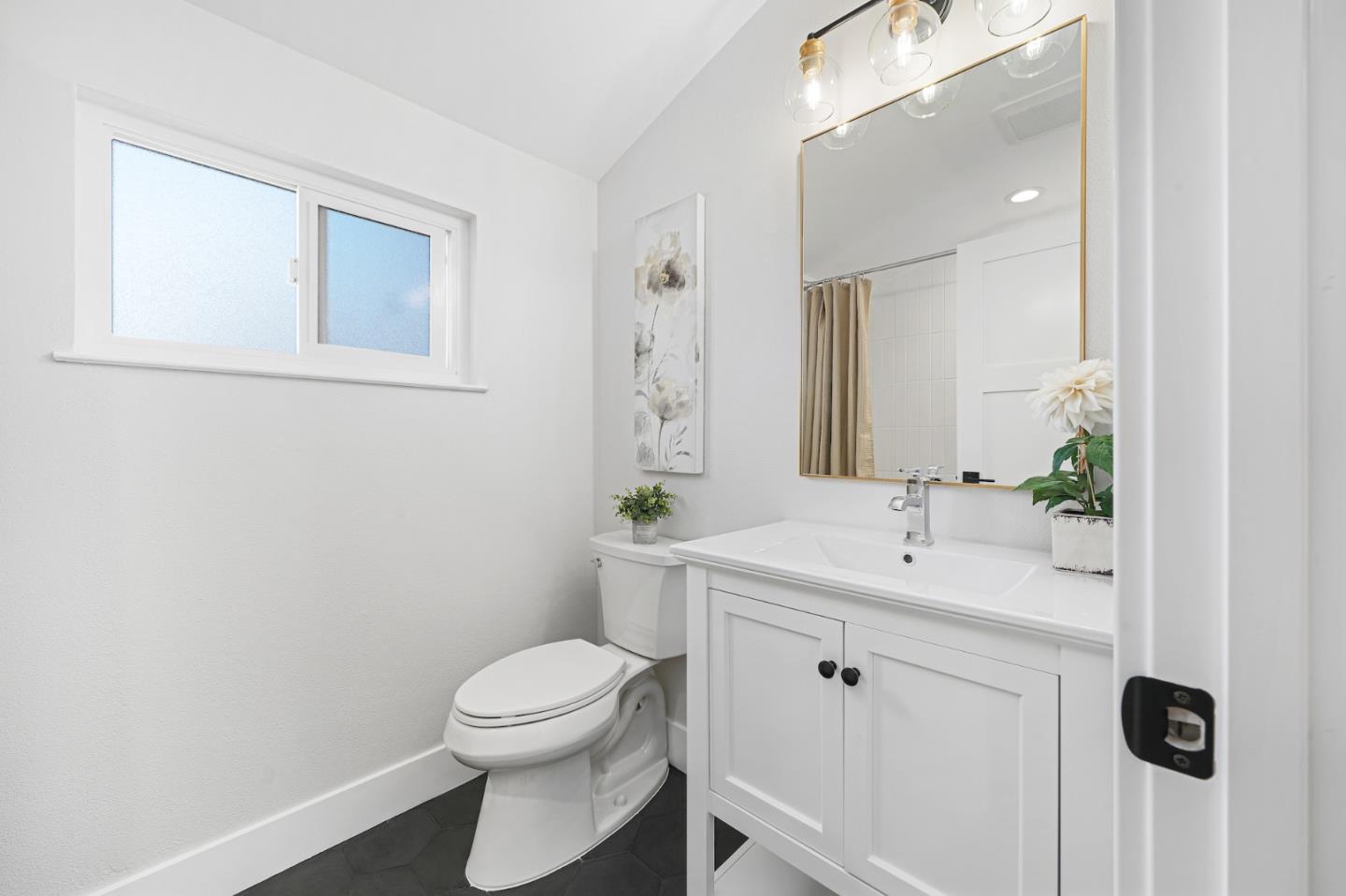 827 Bend Avenue San Jose, CA 95136 - Photo 13 of 27 a bathroom with a toilet a sink a mirror and vanity
