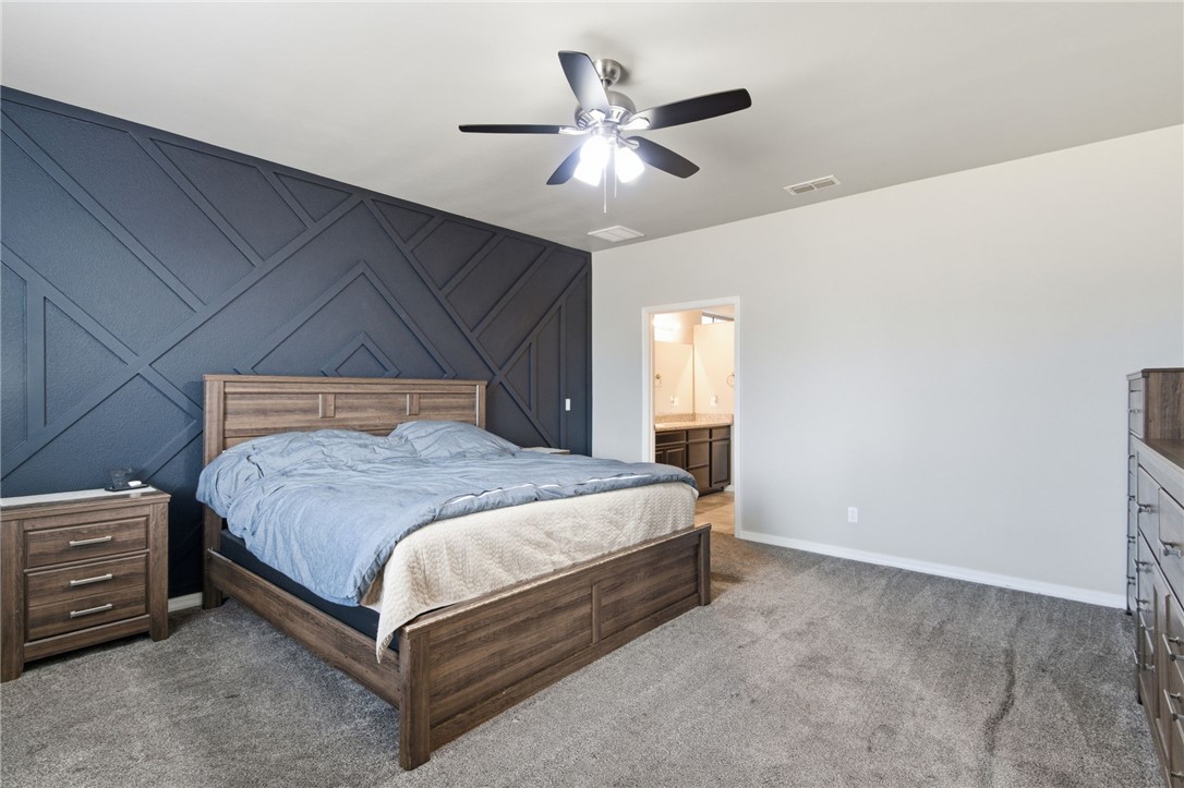4713 North Old Ranch Lane Kingman, AZ 86401 - Photo 18 of 41 a spacious bedroom with a bed and a ceiling fan