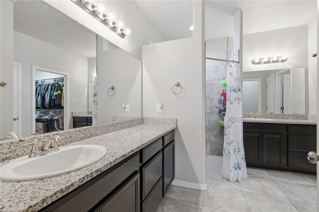 4713 North Old Ranch Lane Kingman, AZ 86401 - Photo 20 of 41 a bathroom with a granite countertop sink a mirror and a shower