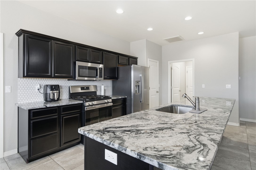 4713 North Old Ranch Lane Kingman, AZ 86401 - Photo 7 of 41 a kitchen with stainless steel appliances kitchen island granite countertop a stove sink and microwave