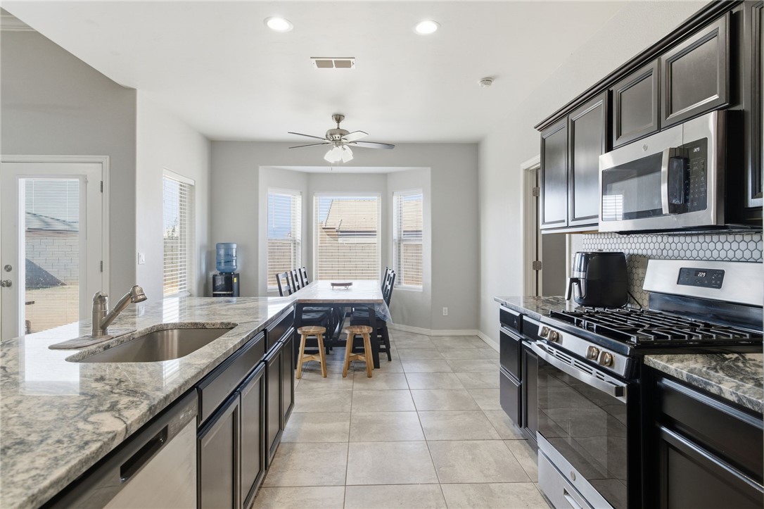 4713 North Old Ranch Lane Kingman, AZ 86401 - Photo 8 of 41 a kitchen with stainless steel appliances granite countertop a sink and a stove