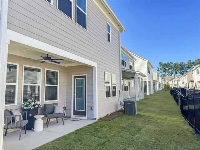 a view of a house with backyard and sitting area