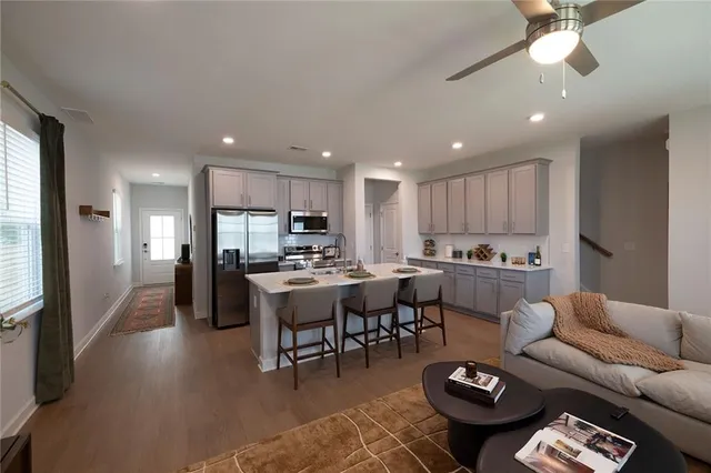 a living room with lots of furniture and view kitchen