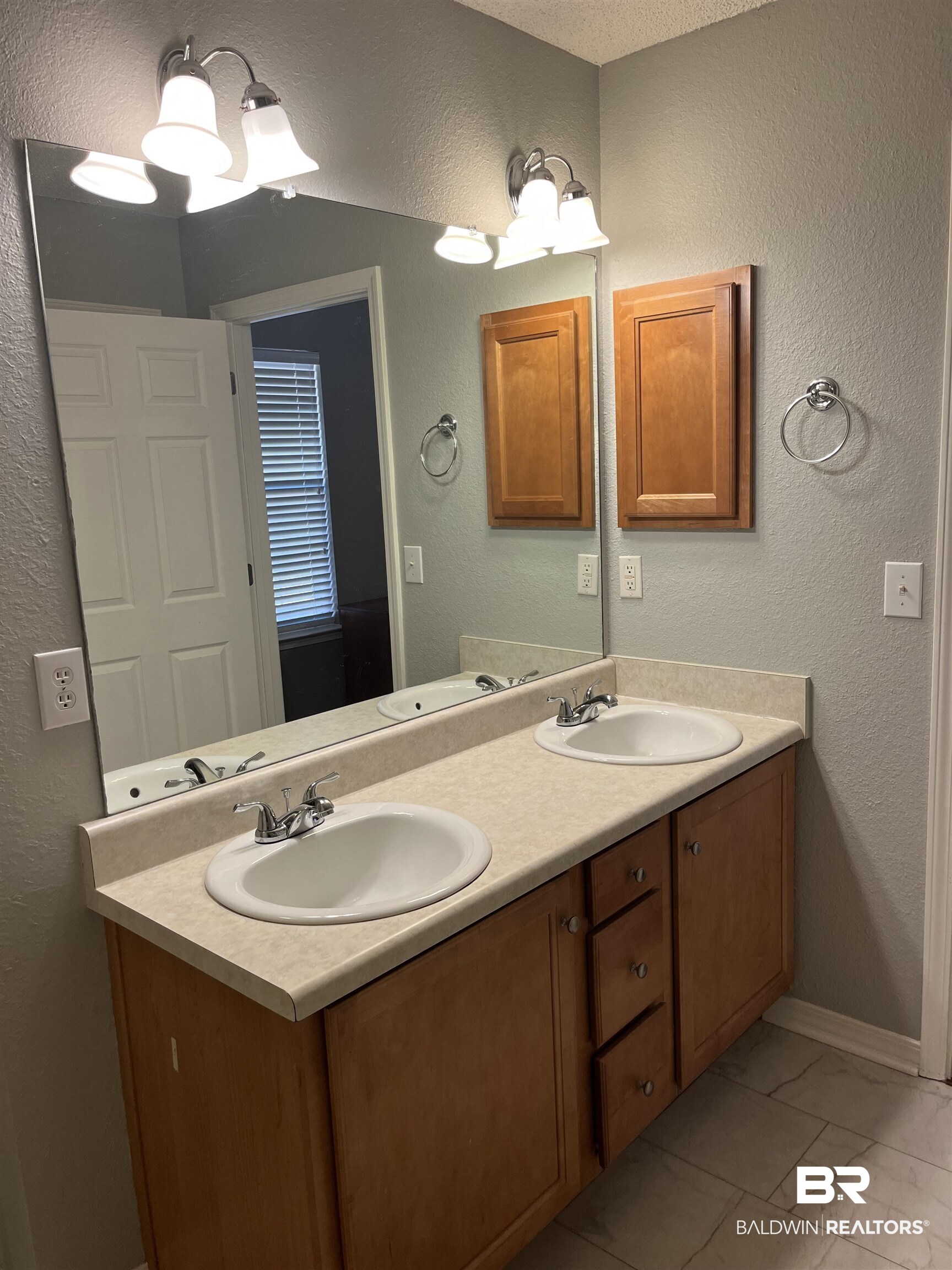 309 Cluster Street Foley, AL 36535 - Photo 15 of 38 Dual vanity featuring wood-finish cabinetry, a light-toned countertop, and two integrated sinks