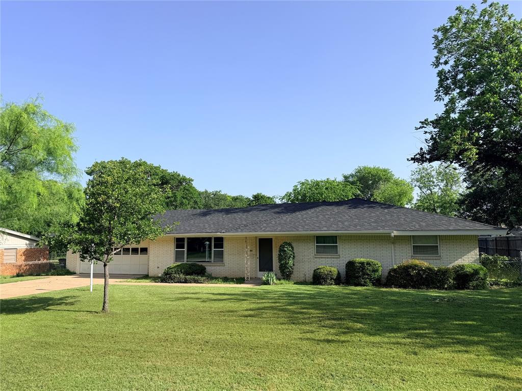 1441 Brazos Street Graham, TX 76450 - Photo 1 of 1 a front view of house with a garden and trees