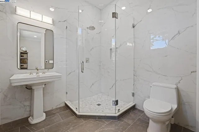 a bathroom with a sink a toilet and shower