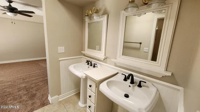 an empty room with wooden floor a ceiling fan and windows