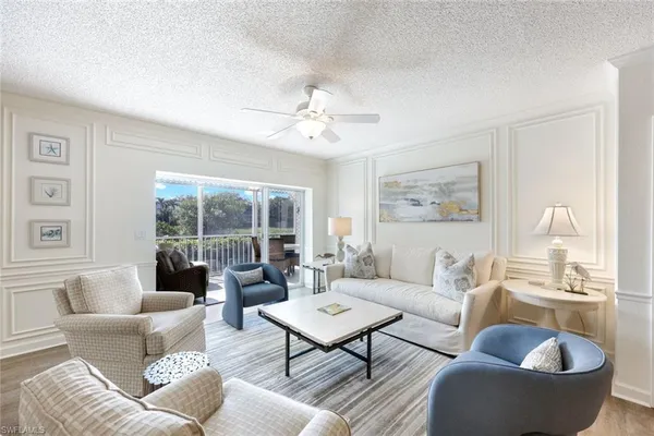 a living room with furniture a table and a large window