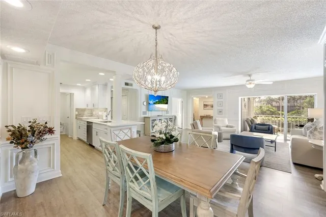 a view of a dining room with furniture a chandelier and wooden floor