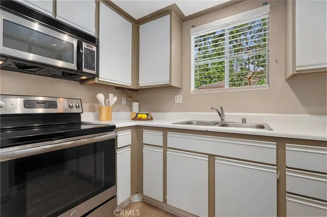 a kitchen with stainless steel appliances granite countertop a sink stove and microwave