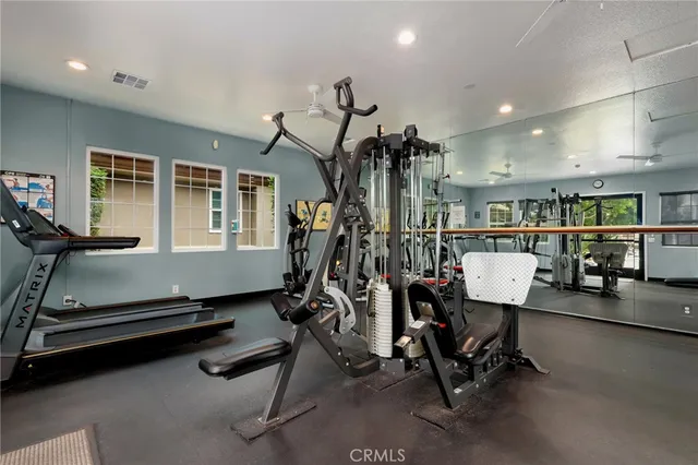 a room with gym equipment and wooden floor