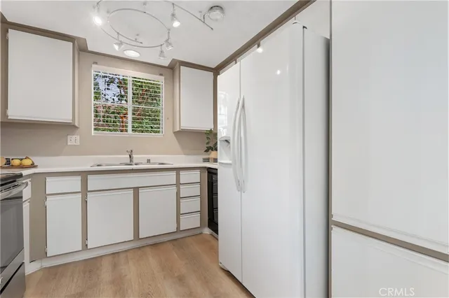 a kitchen with a sink cabinets appliances and a window