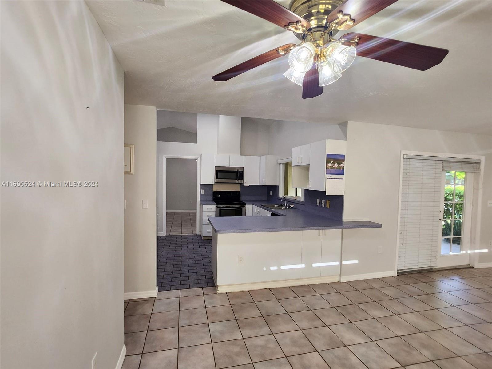 16240 Southwest 286th Street Homestead, FL 33033 - Photo 11 of 14 a living room with furniture and a chandelier