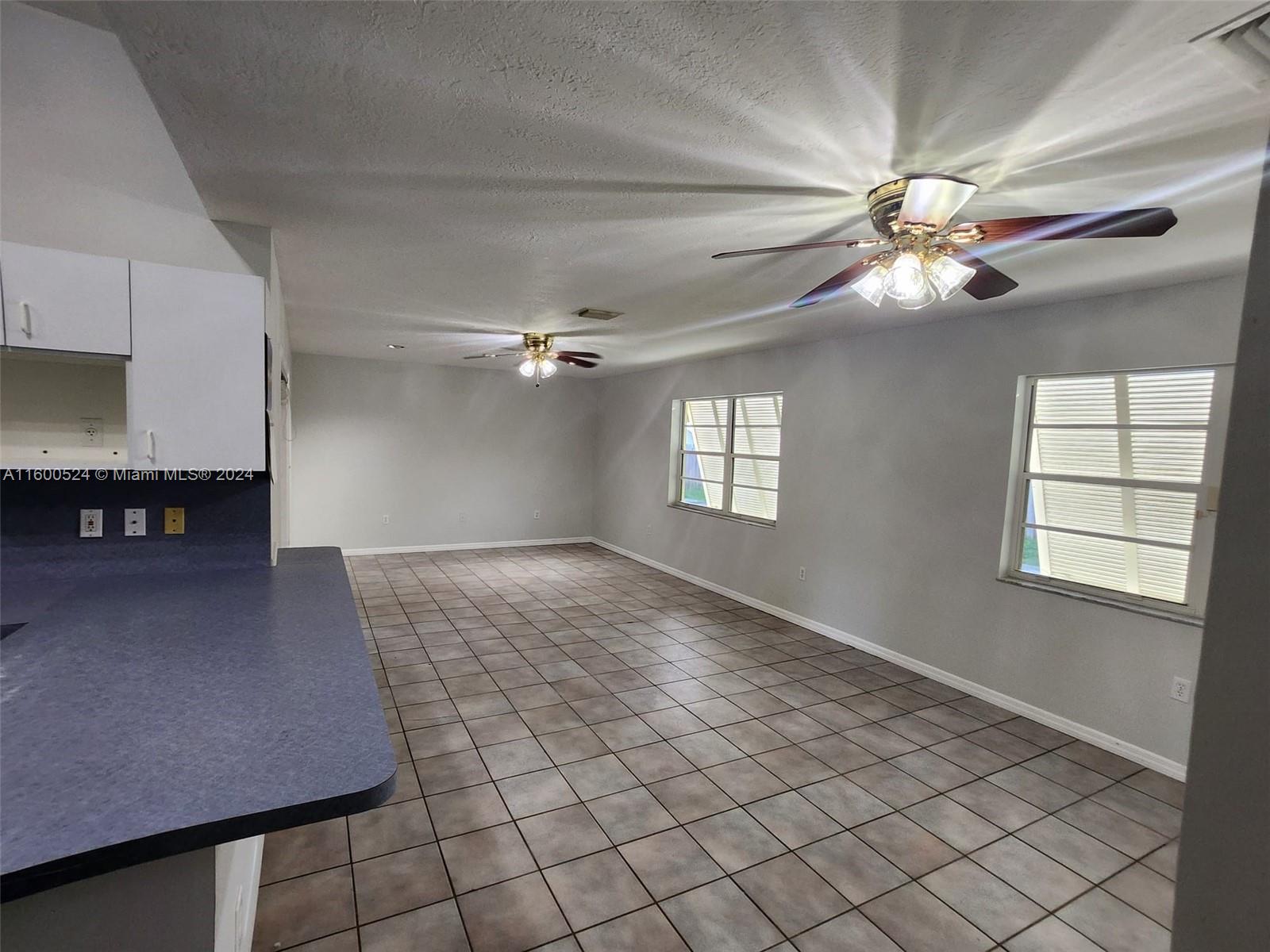 16240 Southwest 286th Street Homestead, FL 33033 - Photo 12 of 14 a view of a livingroom with a ceiling fan and window