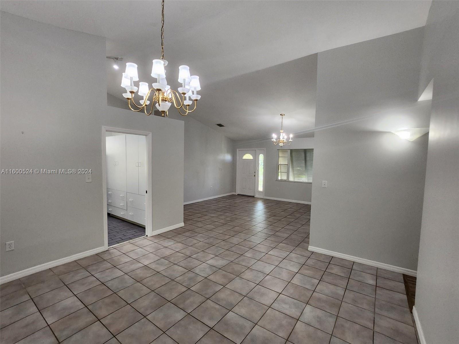 16240 Southwest 286th Street Homestead, FL 33033 - Photo 9 of 14 a view of a livingroom with a chandelier fan and windows