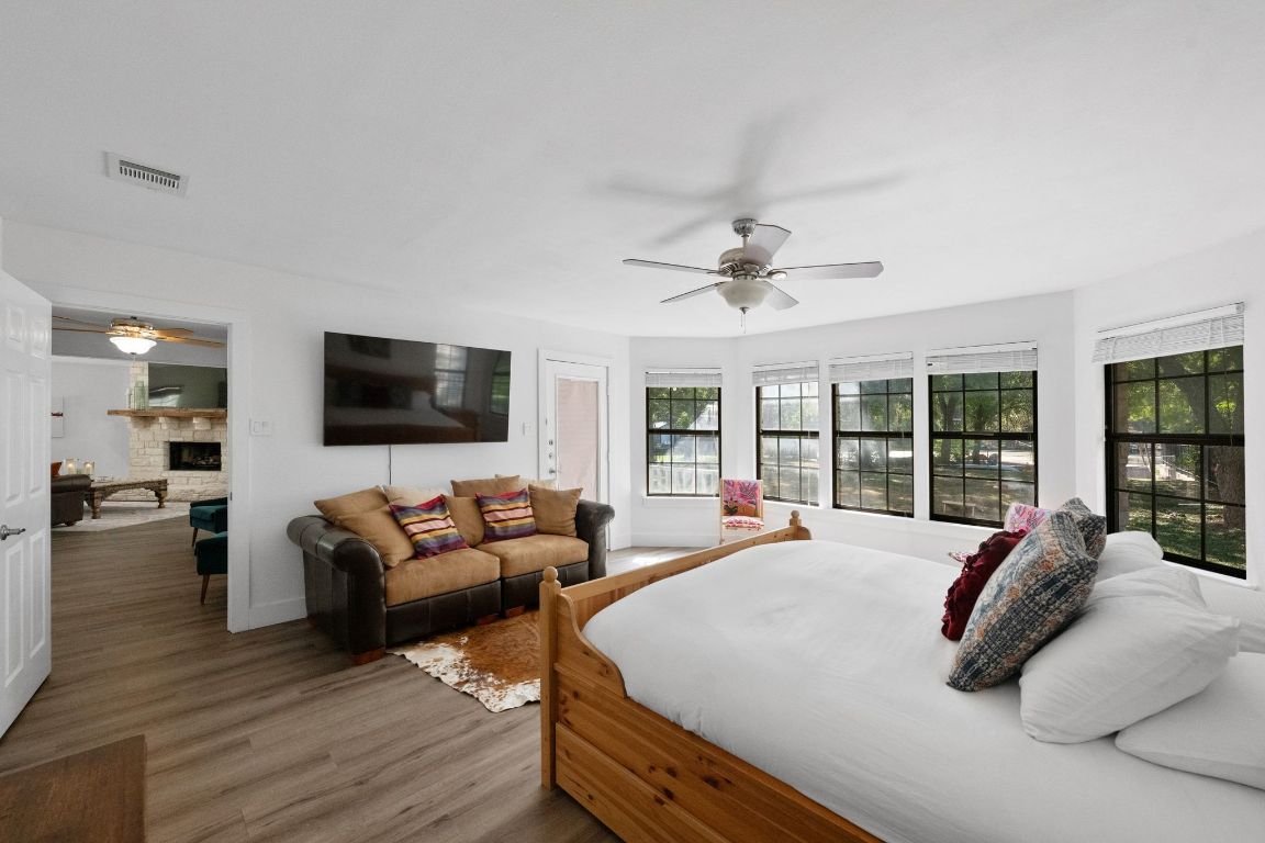 1709 Channel Road Austin, TX 78746 - Photo 15 of 27 a large bedroom with a large bed and a flat screen tv