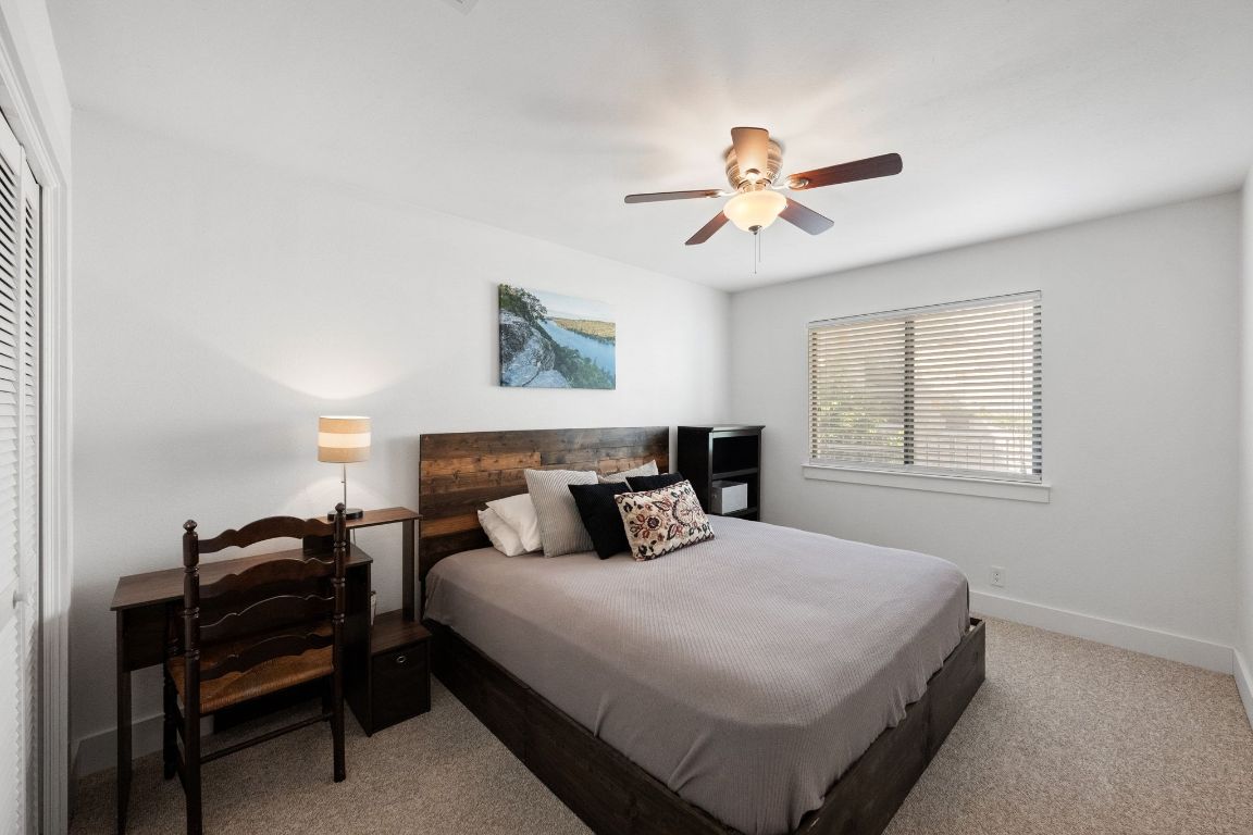 1709 Channel Road Austin, TX 78746 - Photo 21 of 27 a bedroom with a bed and a chandelier