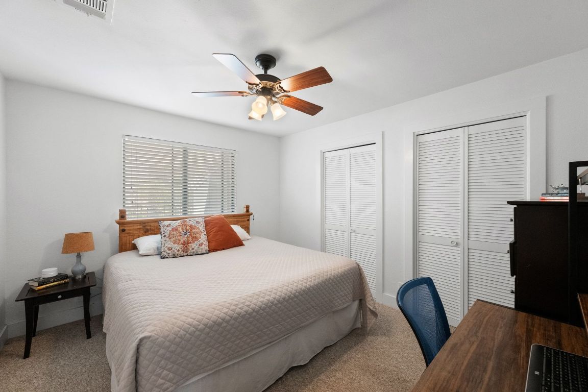1709 Channel Road Austin, TX 78746 - Photo 22 of 27 a bedroom with a bed and wooden floor
