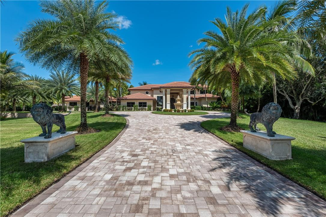 6330 Volunteer Road Southwest Ranches, FL 33330 - Photo 2 of 58 a front view of a house with a yard and palm trees
