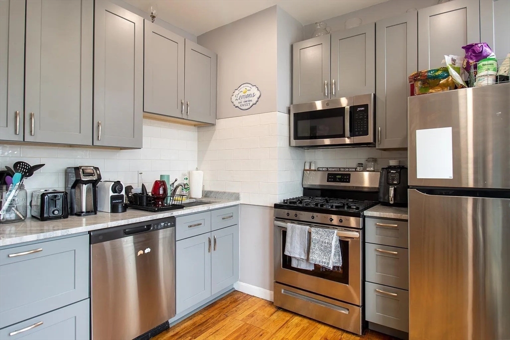 a kitchen with stainless steel appliances granite countertop a refrigerator stove and sink