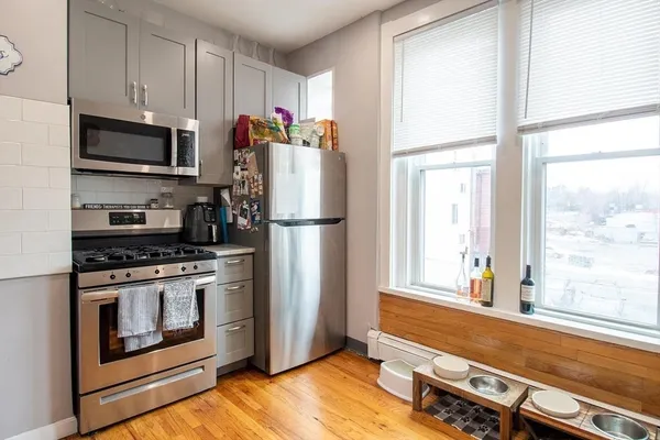 a kitchen with stainless steel appliances a stove microwave and refrigerator