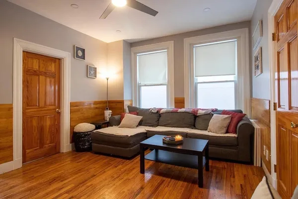 a living room with furniture and a wooden floor