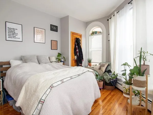 a bedroom with a bed and a potted plant