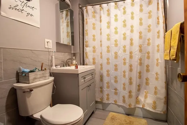 a bathroom with a sink a toilet and shower curtain