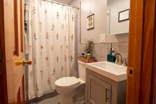a bathroom with a sink a toilet and shower curtain