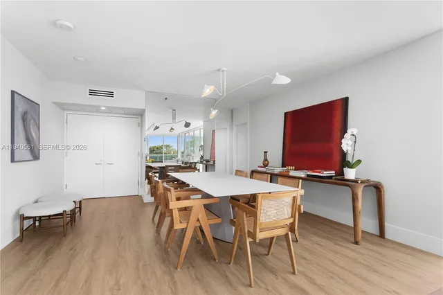 a kitchen with a dining table chairs and white cabinets