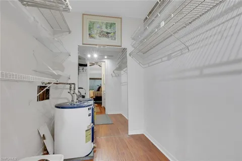 a room with stainless steel appliances wooden floor and chandelier
