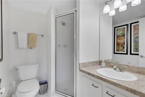 a bathroom with a granite countertop sink a toilet and a mirror