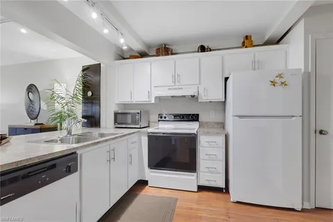 a kitchen with a refrigerator sink and cabinets