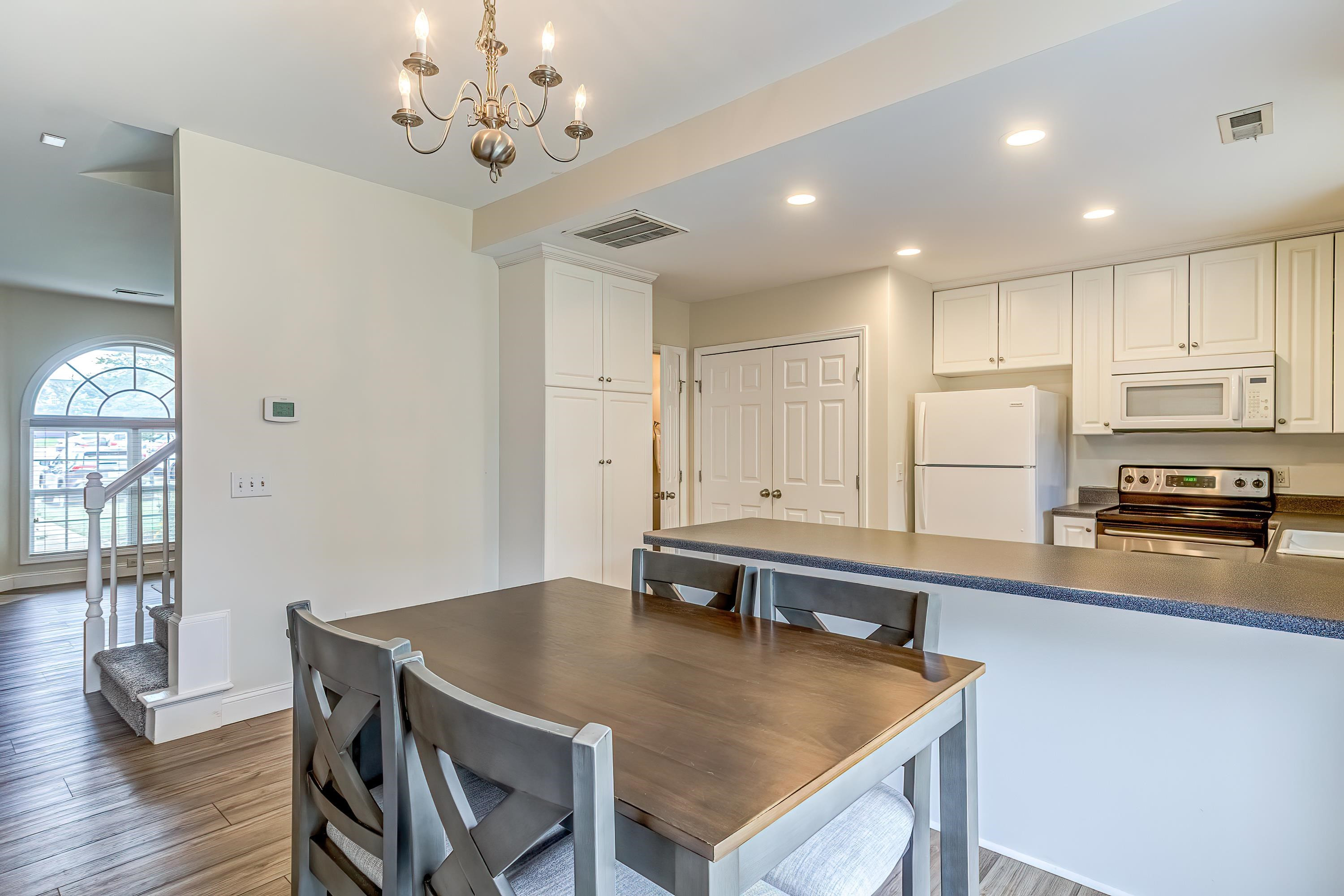 2131 Piney Brook Road, Unit 104 Raleigh, NC 27614 - Photo 13 of 37 a kitchen with stainless steel appliances granite countertop a stove refrigerator a sink dishwasher with a dining table and chairs