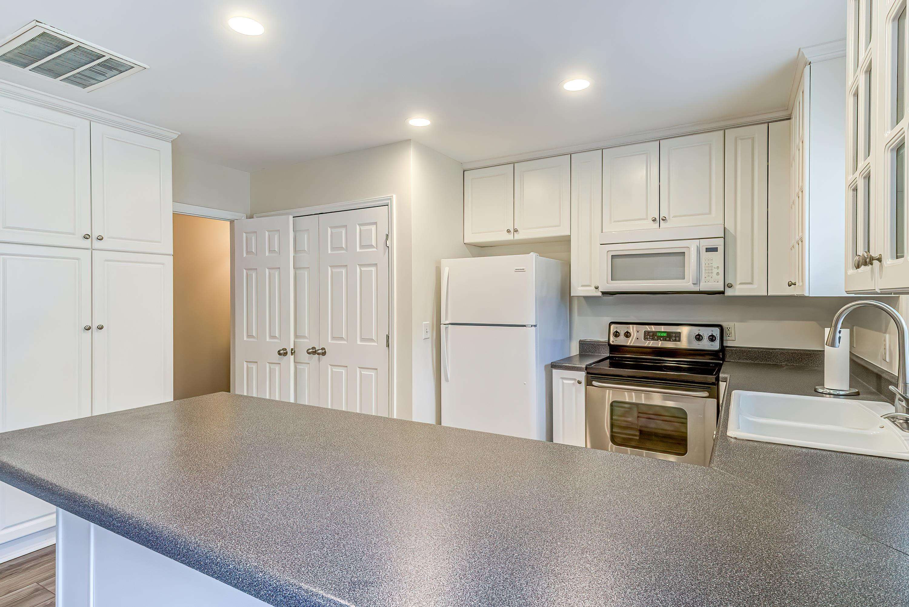 2131 Piney Brook Road, Unit 104 Raleigh, NC 27614 - Photo 15 of 37 a kitchen with stainless steel appliances granite countertop a refrigerator a stove and a sink with wooden floor