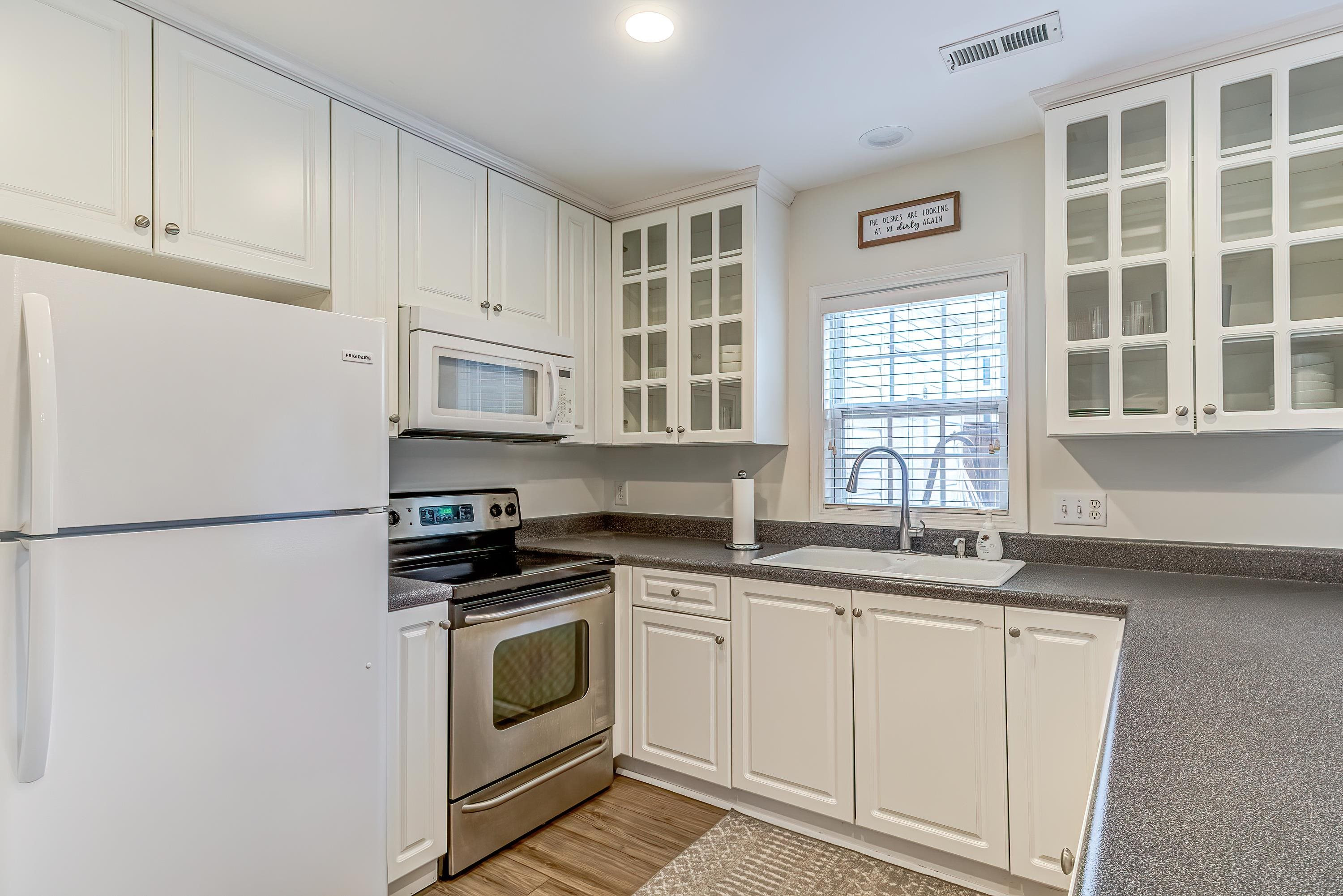 2131 Piney Brook Road, Unit 104 Raleigh, NC 27614 - Photo 17 of 37 a kitchen with white cabinets and white appliances