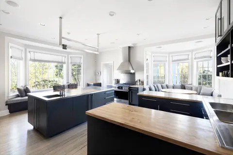 a kitchen with kitchen island granite countertop a sink appliances and cabinets