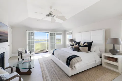 a large bedroom with a bed and large windows