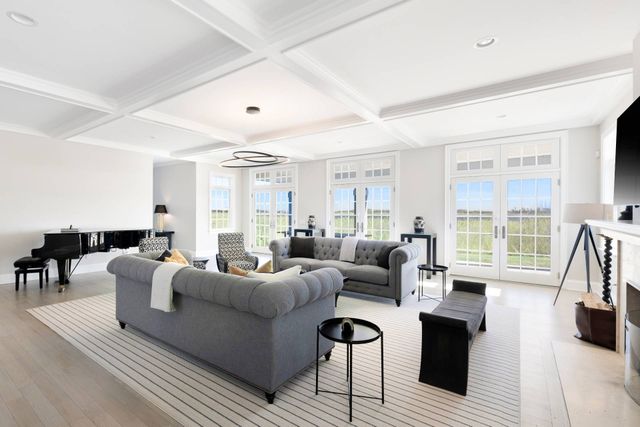 a living room with furniture a large window and a wooden floor