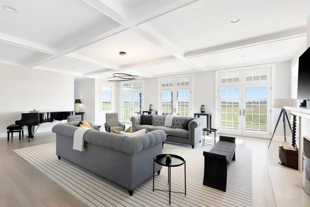 a living room with furniture a large window and a wooden floor