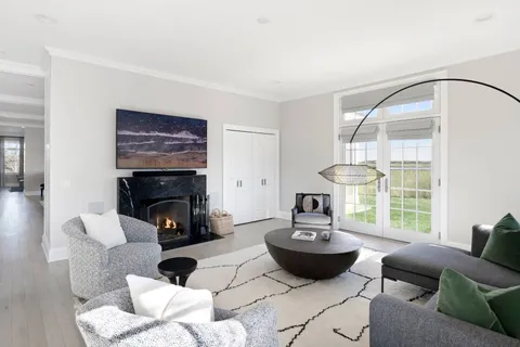 a living room with furniture a fireplace and a large window