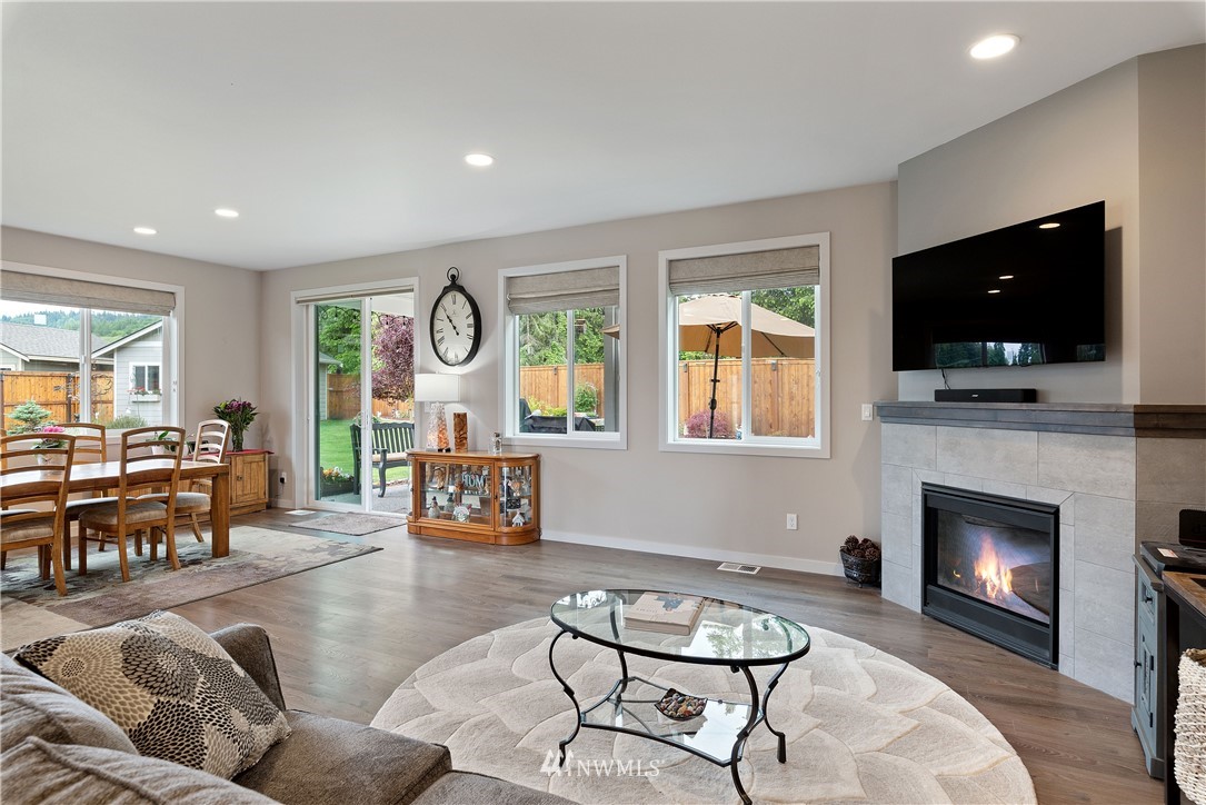 320 Blue Glacier Loop Sequim, WA 98382 - Photo 15 of 38 a living room with furniture a flat screen tv and a fireplace